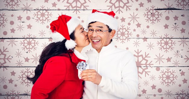 Image composée du couple aîné festif échangeant des cadeaux