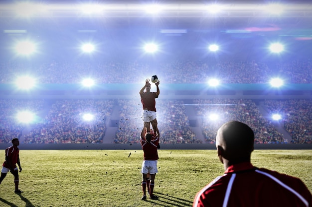 Image composée du joueur de rugby attrapant la boule dans le ciel