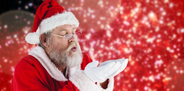 Image composée du père noël dans des lunettes soufflant la neige invisible