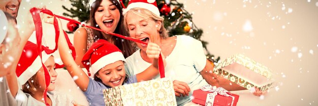 Image composée de famille heureuse aux cadeaux d'ouverture de Noël ensemble