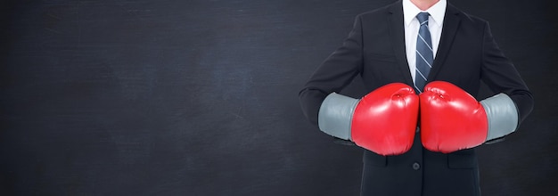 Image composée d'homme d'affaires avec des gants de boxe