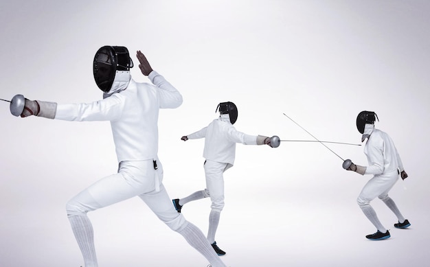 Photo image composée d'homme portant le costume d'escrime pratiquant avec l'épée