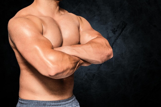 Image composée de section médiane d'un homme de bodybuilder avec des bras croisés