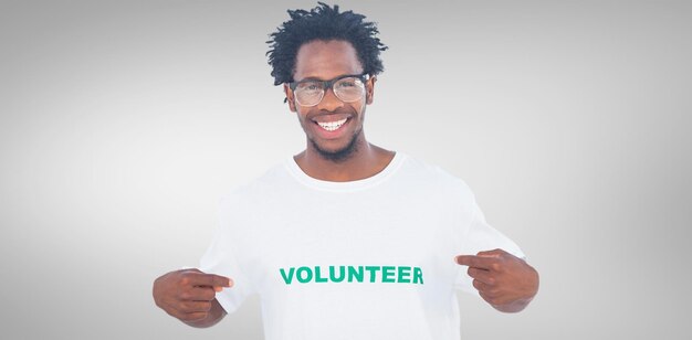 Photo image composite de bel homme pointant vers son t-shirt bénévole