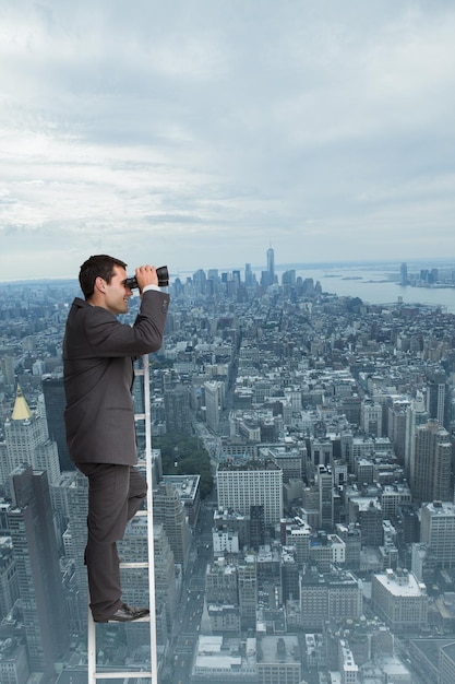 Image composite de businessman standing on ladder