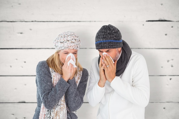 Image composite de couple malade en mode hiver éternuements