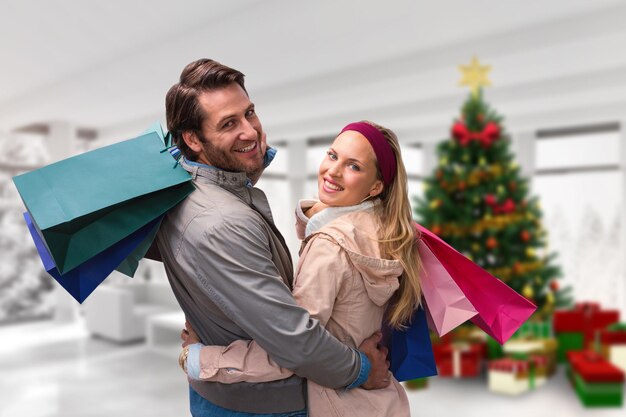 Image composite de couple souriant avec des sacs à provisions embrassant