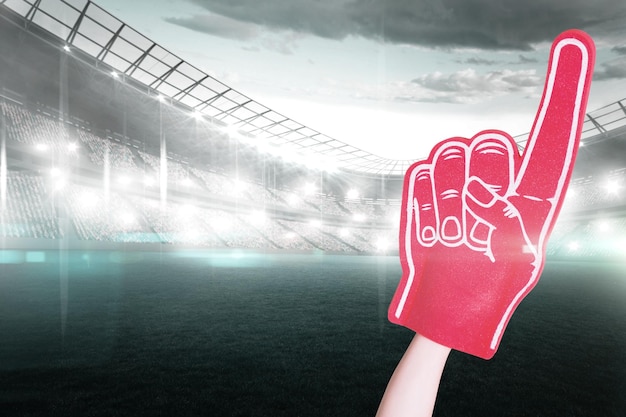 Image composite du joueur de football américain tenant la main en mousse de supporter