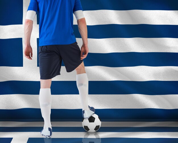 Image composite du joueur de football debout avec ballon contre drapeau national grec généré numériquement