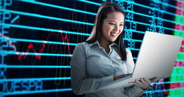 Image composite d'une femme d'affaires souriante utilisant un ordinateur portable