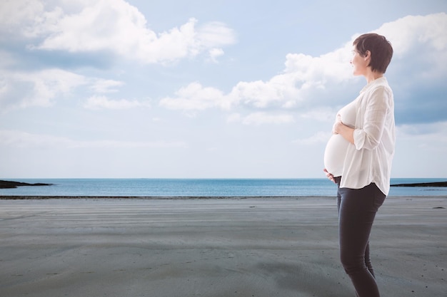 Image composite de femme enceinte debout sur un tapis sur fond blanc