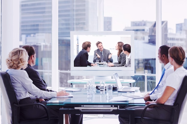 Image composite d'un groupe de gens d'affaires regardant un écran