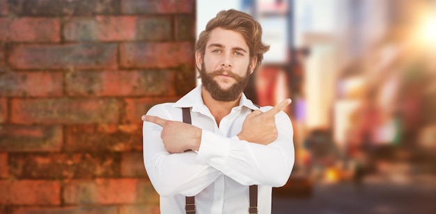 Photo image composite d'un hipster confiant pointant sur le côté avec les bras croisés