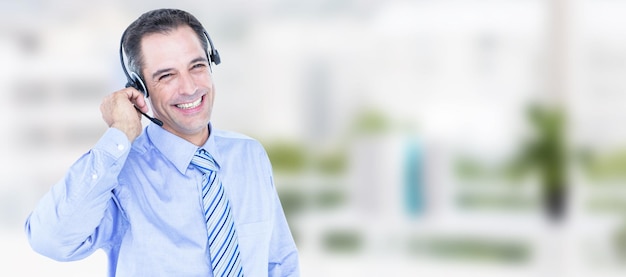 Image composite d'un homme d'affaires souriant à l'aide d'un casque