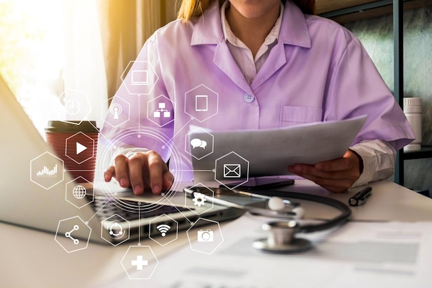 Image composite numérique d'un médecin utilisant un ordinateur portable avec des icônes