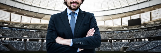 Image composite de portrait of businessman standing avec les bras croisés