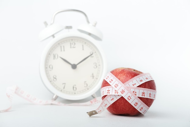 Image de concept d'alimentation saine une pomme avec un ruban à mesurer sur un fond blanc isolé