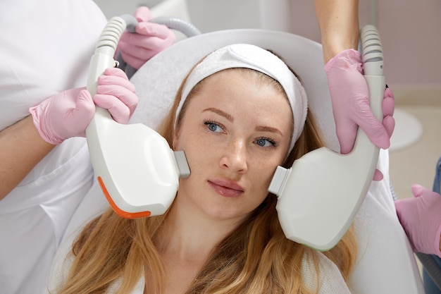 Photo image conceptuelle de beauté et de cosmétique de mains de plusieurs médecins tenant un équipement laser au-dessus
