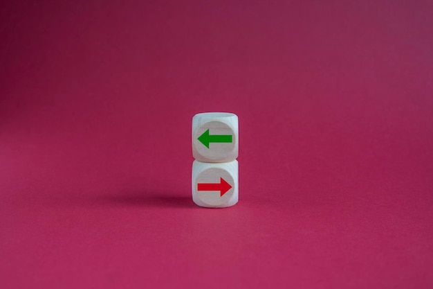 Image conceptuelle de choix et de direction Cubes en bois avec des flèches pointant dans des directions opposées