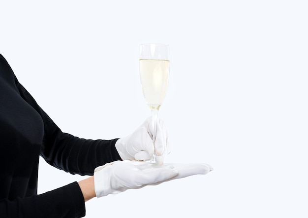 Image d'une coupe de champagne dans des mains féminines. Gants blancs. Fond de studio clair. Technique mixte