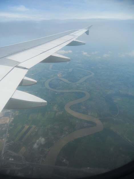 Photo image coupée d'une aile d'avion au-dessus du paysage