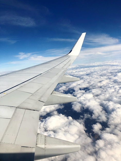 Image coupée d'une aile d'avion volant contre le ciel
