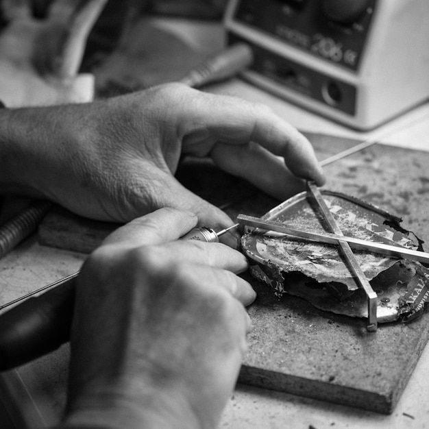 Photo image coupée d'un artisan travaillant sur le métal à l'atelier