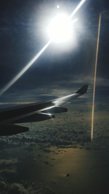 Photo image coupée d'un avion volant au-dessus de la mer contre un ciel brillant