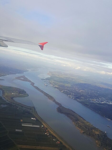 Image coupée d'un avion volant au-dessus de la mer contre un ciel nuageux