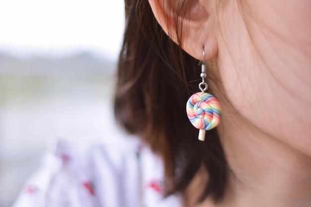 Photo image coupée d'une femme portant une boucle d'oreille en forme de sucette