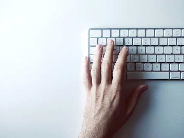 Photo image coupée d'une frappe à la main sur un clavier d'ordinateur sur un fond blanc