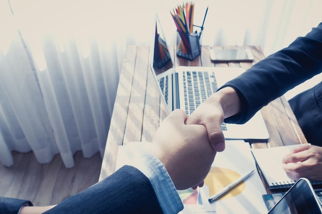 Image coupée de gens d'affaires se serrant la main au bureau dans un bureau