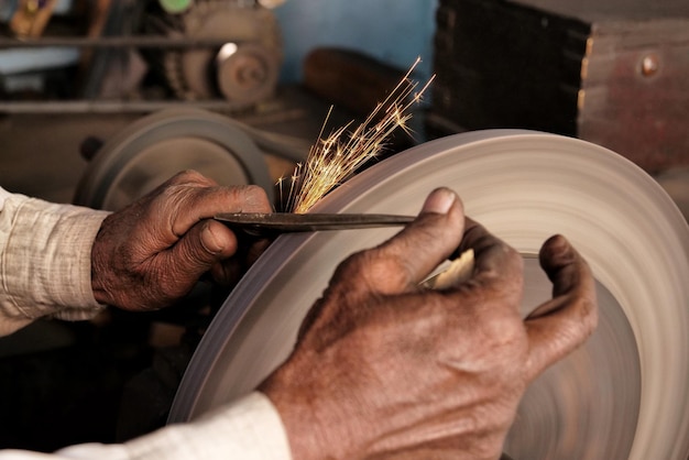 Photo image coupée d'un homme aiguisant un couteau