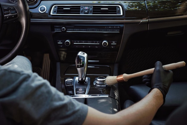 Image coupée d'un homme nettoyant un bouton dans une voiture