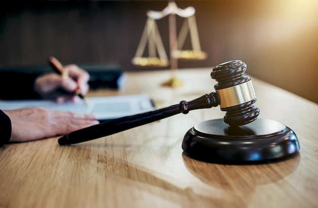 Image coupée d'un juge écrivant avec un marteau sur la table