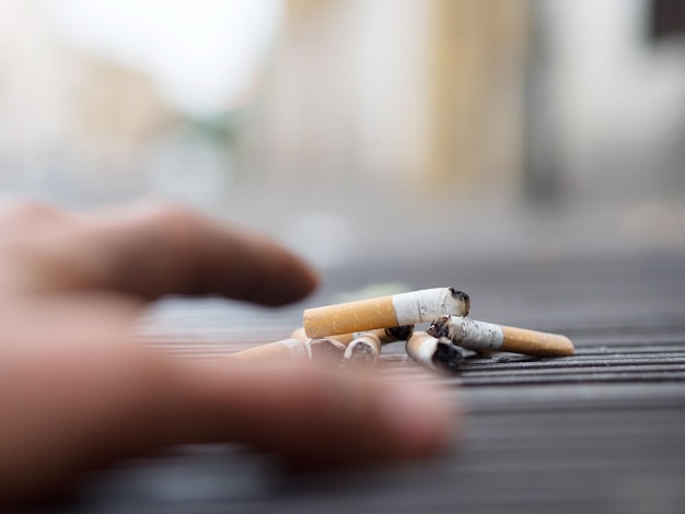 Image coupée d'une main atteignant une cigarette