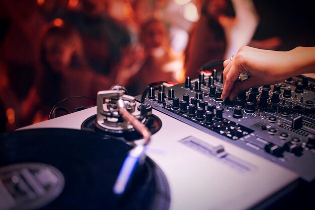 Image coupée d'une main utilisant un DJ intelligent lors d'un concert de musique nocturne