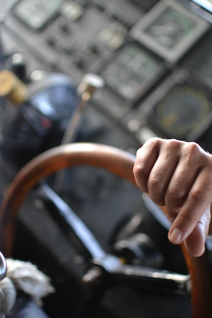 Photo image coupée d'une main sur le volant d'un bateau