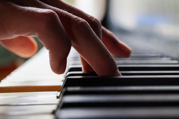 Image coupée de mains jouant du piano