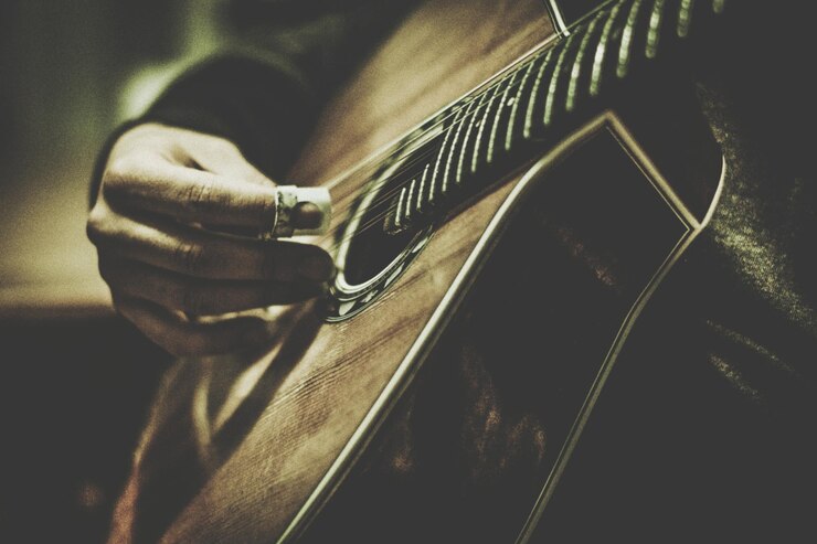 Photo image coupée d'un musicien jouant de la guitare acoustique