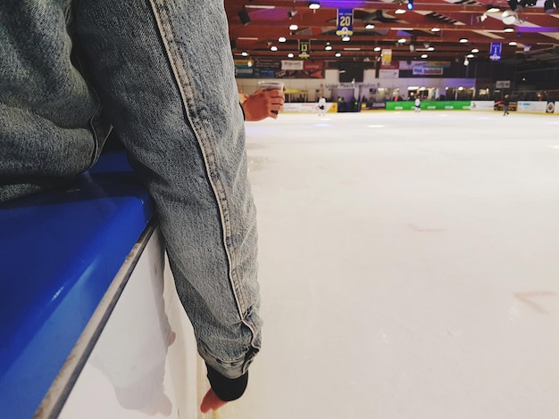 Image coupée d'une personne assise sur un siège près de la patinoire