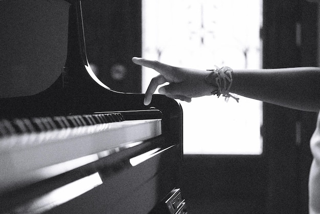 Image coupée d'une personne jouant du piano à la maison