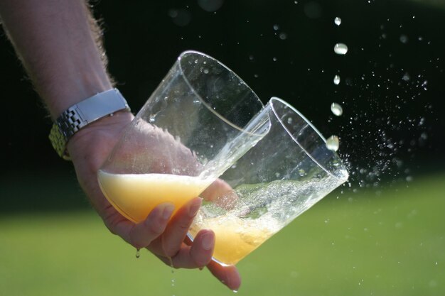 Photo image coupée d'une personne tenant des verres de jus