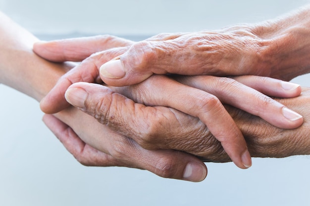Image coupée de personnes âgées s'empilant les mains à l'extérieur