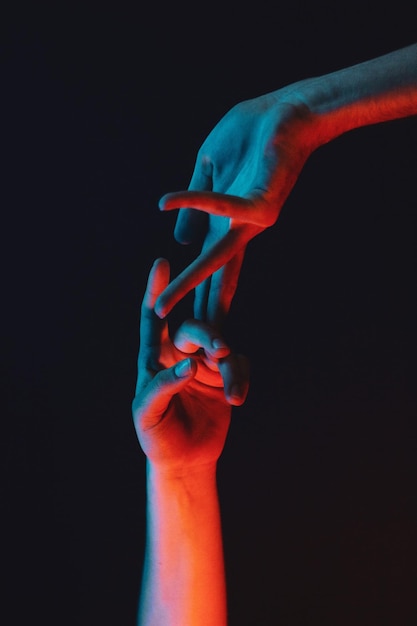 Image coupée de personnes touchant des doigts sur un fond noir