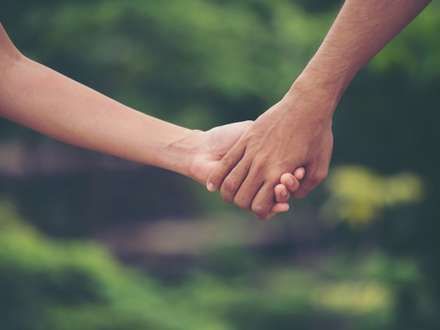 Image de couple tenant les mains ensemble.