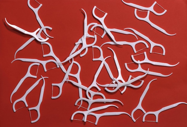 Image de cure-dents blancs avec un fil sur un fond rouge