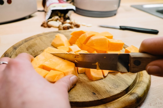 Photo image découpée de mains coupant des citrouilles sur une planche à découper