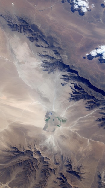 Une image d'un désert avec des montagnes et des nuages.