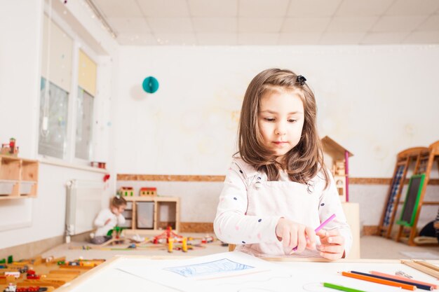 Image de dessin de petite fille créative avec des crayons bleus